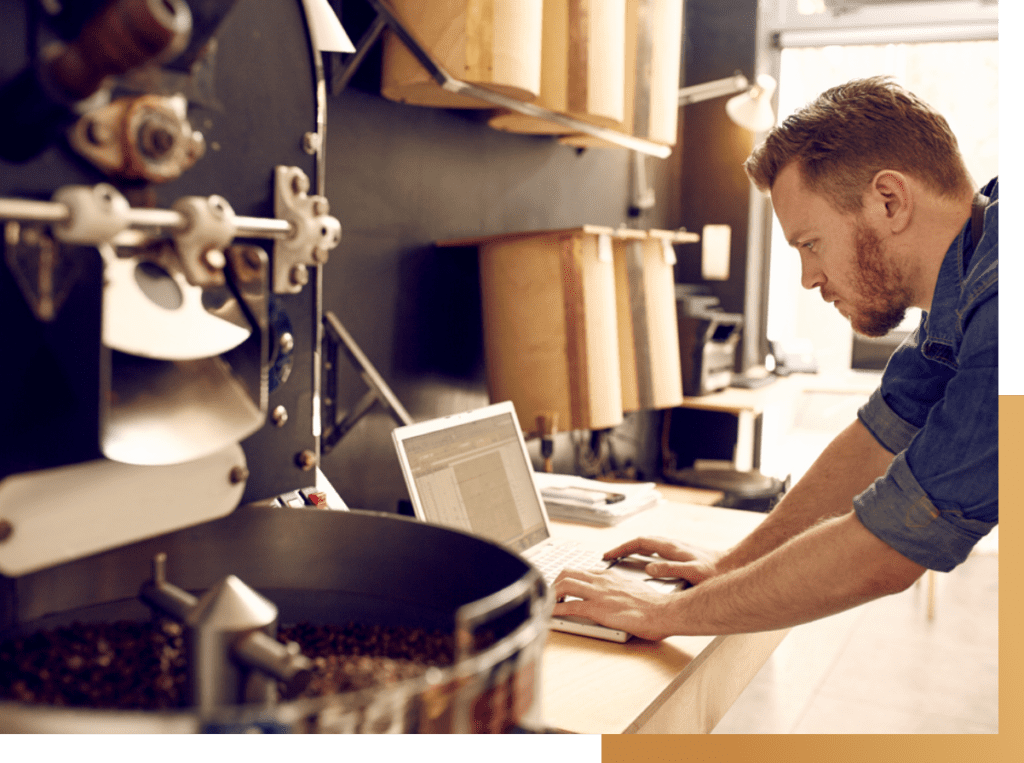 man working on his laptop in front of mechanical work station
