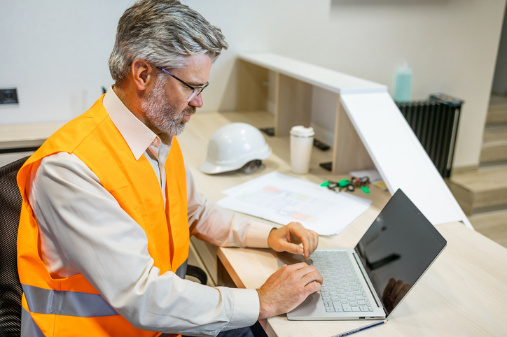 Facility manager on site utilising a CAFM software system to efficiently manage his facility management tasks